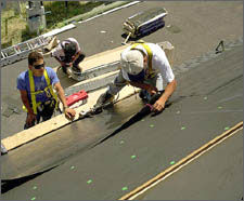 A photo of PV shingles being installed on a roof.